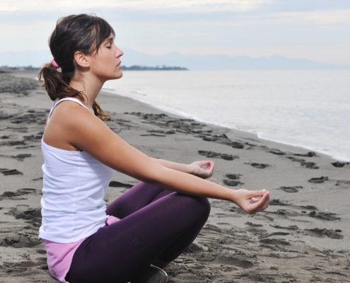 woman yoga beach deep breathing exercises